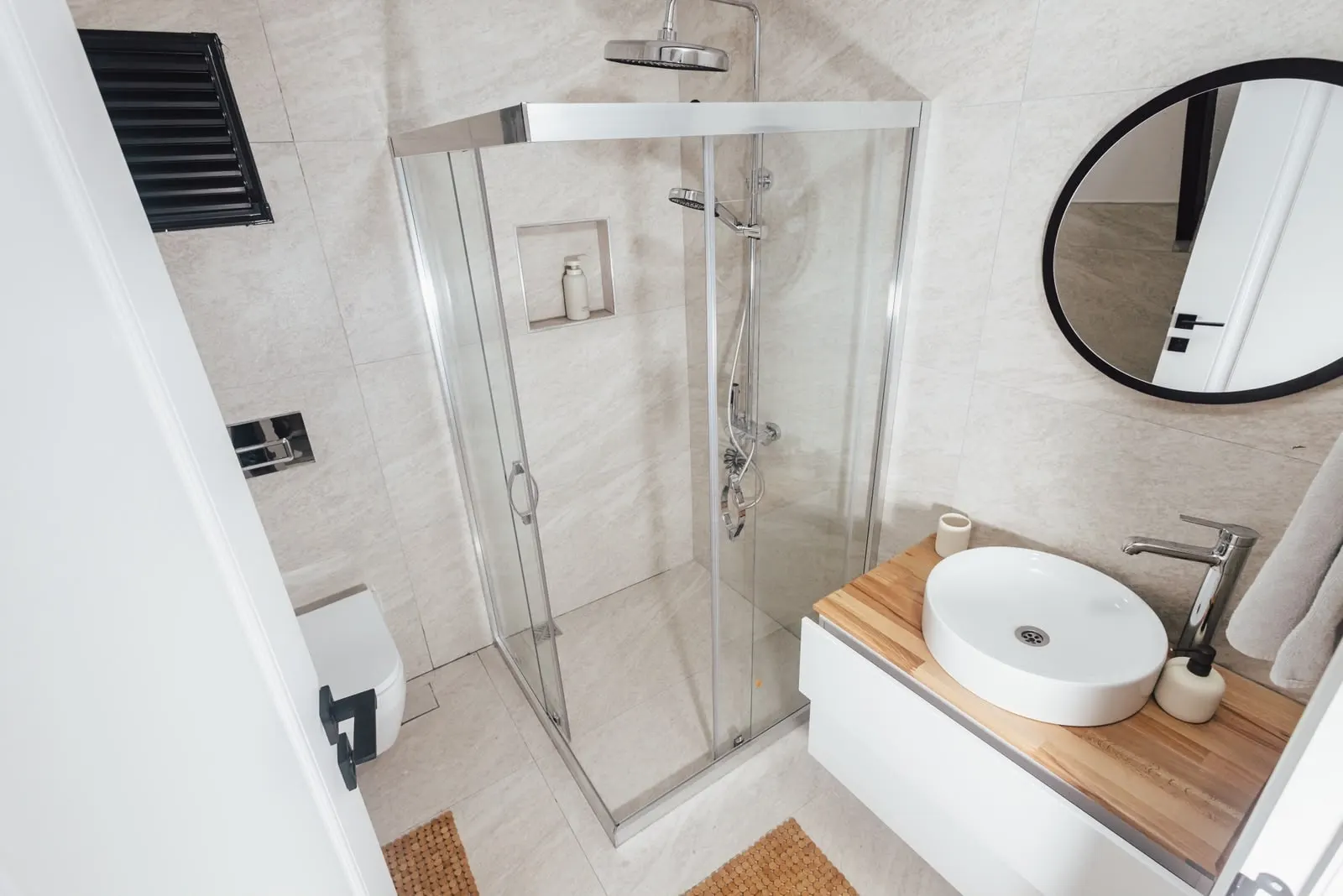 Duş kabini, lavabo ve yuvarlak ayna